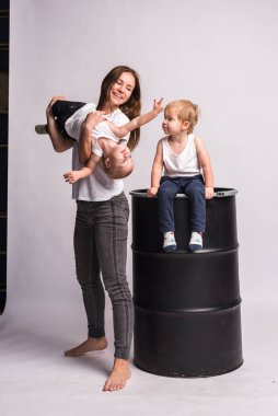 Mutlu bir Avrupalı aile birlikte vakit geçirir, aile mutludur. Anne, oğul, iki oğul, gülümseyen ve oyalanan, çılgınca eğlenen. Aileyle vakit geçirmek. Hepsi beyaz tişört ve kot pantolon giymiş, rahat giyimli.