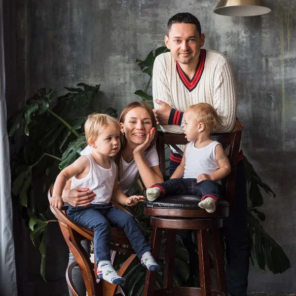 Mutlu Avrupalı aile birlikte vakit geçiriyor, aile mutlu. Anne, baba, oğul, iki oğul, gülümseyen ve eğlenen, çılgınca eğlenen. Aileyle vakit geçirmek. Hepsi beyaz tişört ve kot pantolon giymiş, rahat giyimli.