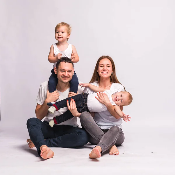 Mutlu Avrupalı aile birlikte vakit geçiriyor, aile mutlu. Anne, baba, oğul, iki oğul, gülümseyen ve dalga geçen, çılgın bir eğlence. Aileyle vakit geçirmek. Hepsi beyaz tişört ve kot pantolon giymiş, rahat giyimli.