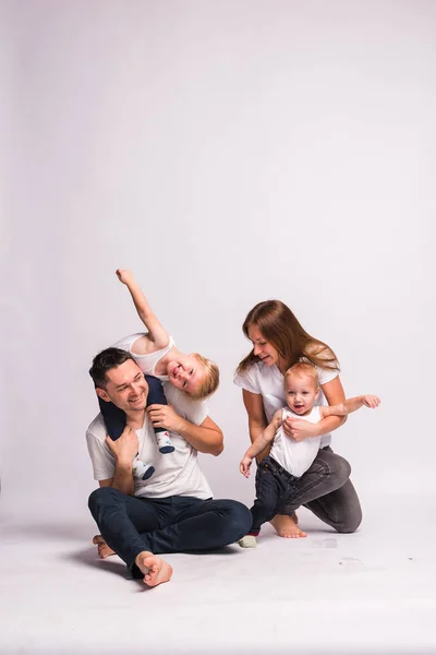 happy European family spend time together, the family is happy. mom, dad, son, two sons, smiling and messing around, crazy fun. Spending time with family. all dressed in white t-shirts and jeans, comfortable clothing style