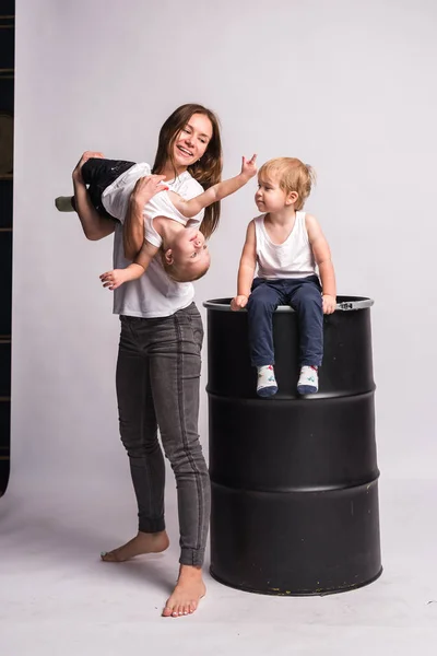 Mutlu bir Avrupalı aile birlikte vakit geçirir, aile mutludur. Anne, oğul, iki oğul, gülümseyen ve oyalanan, çılgınca eğlenen. Aileyle vakit geçirmek. Hepsi beyaz tişört ve kot pantolon giymiş, rahat giyimli.