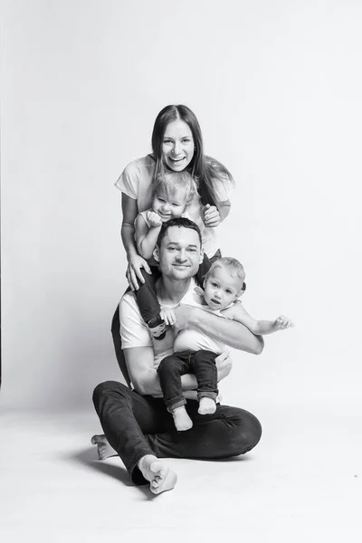Mutlu Avrupalı aile birlikte vakit geçiriyor, aile mutlu. Anne, baba, oğul, iki oğul, gülümseyen ve dalga geçen, çılgın bir eğlence. Aileyle vakit geçirmek. Hepsi beyaz tişört ve kot pantolon giymiş, rahat giyimli.