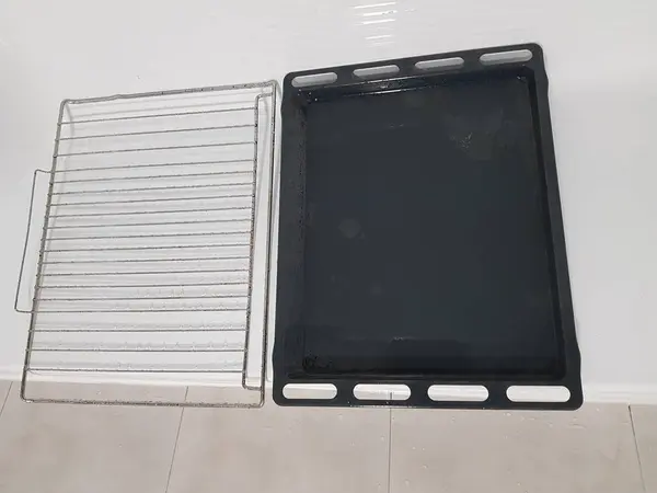 Fırın ızgarasının yanında temiz bir fırın tepsisi duruyor. Temizlik, genel temizlik, temizlik. Pislik falan yok. yemek temiz
