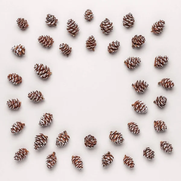 Christmas frame made of pine cones. Winter pattern. Flat lay, top view.