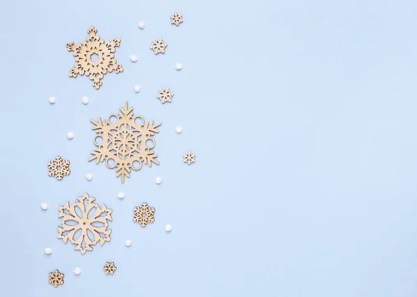 Tahta kar taneleri ve beyaz ponponlardan yapılmış Noel mavisi kompozisyon. Düz yatış, üst görünüm