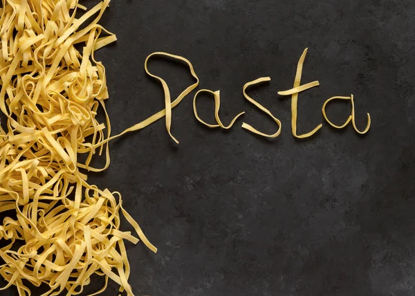 Word Pasta Φτιαγμένο Από Tagliatelle Μαύρο Φόντο Άνω Όψη — Φωτογραφία Αρχείου