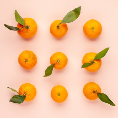 Pembe arka planda taze meyvelerden yapılmış mandalina deseni. Üst görünüm