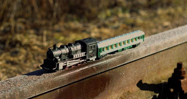 Oyuncak tren demir raylar üzerinde, seçici bir odak noktası.