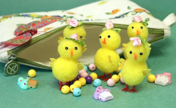 yellow toy chickens with beads on a green background
