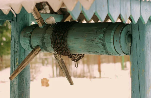 Bir kova zincirli ahşap bir kuyu.