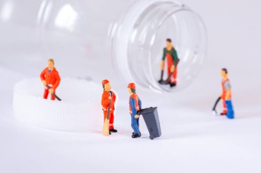 Minyatür İşçiler plastik bir şişeyi temizleyip geri dönüştürüyorlar
