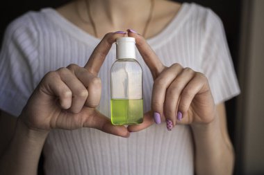 Kadın eli, ellerin tedavisi için yeşil bir antiseptik tutar. Kendini soyutlama. Hijyene dikkat..