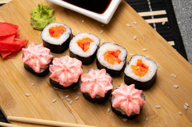 Tahta tahtada sebzeli vejetaryen dürümleri. Beyaz bardakta soya sosu.