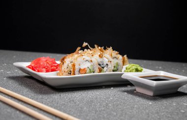 Ton balıklı rulo ve beyaz tabakta kırmızı balık. Soya soslu kırmızı Ginger White cup. Gri arka plan. Çin yemek çubukları.