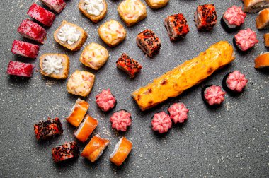 Büyük fırınlanmış ve soğuk dürümler. Balıklı suşi. Gri arkaplan