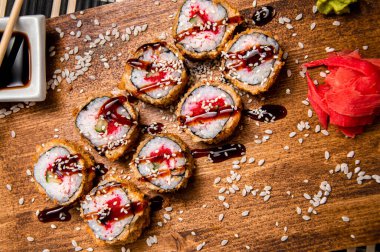 Kızarmış ekmek, salatalık ve tavuk. Ahşap arka plan. Soslu beyaz bardak. Çin yemek çubukları.