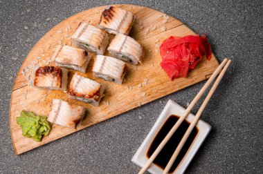 Tütsülenmiş yılan balığı ahşap bir stantta yuvarlanıyor. Menü için fotoğraf.