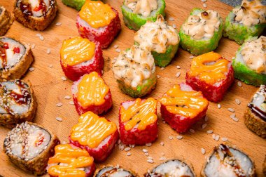 Ahşap bir yüzeyde sos ile pişirilmiş rulo Seth. Arkaplanda pirinç