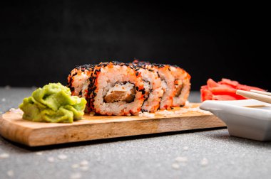 Siyah susam tohumlu turuncu rulo. Tahta yüzey. Menü için fotoğraf