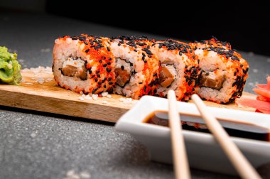 Siyah susam tohumlu turuncu rulo. Tahta yüzey. Menü için fotoğraf