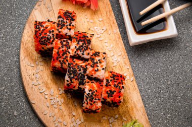 Siyah susam tohumlu turuncu rulo. Tahta yüzey. Menü için fotoğraf