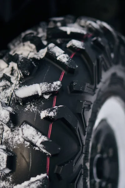 ATV off-road lastiği karda. Koruyucunun yakın çekimi.