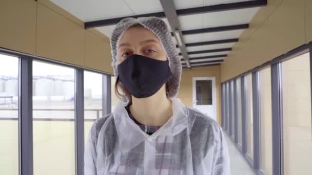 Νεαρή κοπέλα με μπουρνούζι και μάσκα με αυτοπεποίθηση κοιτάζει την κάμερα — Αρχείο Βίντεο