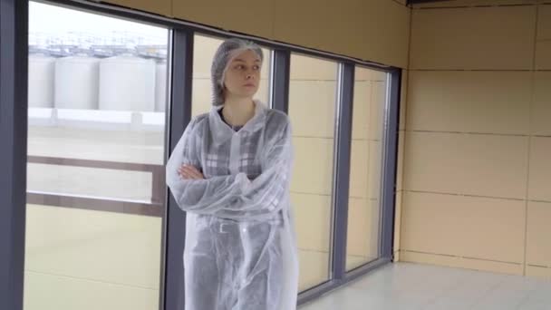 A young girl in medical clothes is walking along a glass corridor — Stock Video