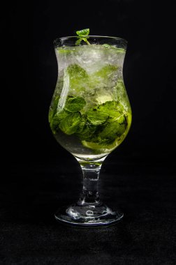 Limonlu, naneli ve buzlu mojito. İzole edilmiş, siyah bir arkaplanda güzel bir kokteyl..