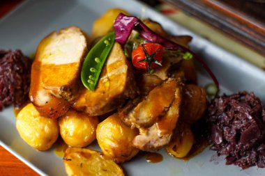 Restoran masasındaki gurme tavuk yemeğinin yakın plan görüntüsü.