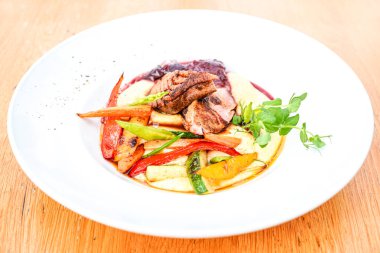 Tahta masadaki lezzetli ana yemek tabağının yakın çekimi. 