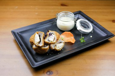 Lokantadaki ahşap masada nefis ana yemek tabağının yakın çekimi.