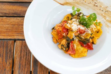 Lokantadaki ahşap masada nefis ana yemek tabağının yakın çekimi.