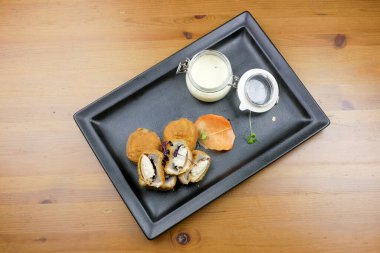 Lokantadaki ahşap masada nefis ana yemek tabağının yakın çekimi.