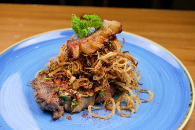 Lokantadaki ahşap masada nefis ana yemek tabağının yakın çekimi.