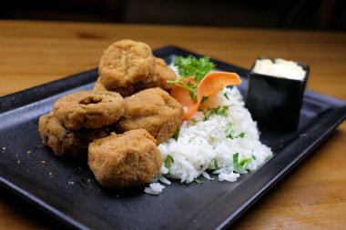 Lokantadaki ahşap masada nefis ana yemek tabağının yakın çekimi.