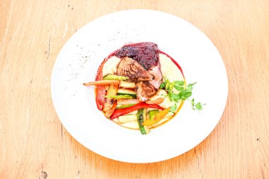 Tahta masadaki lezzetli ana yemek tabağının yakın çekimi. 