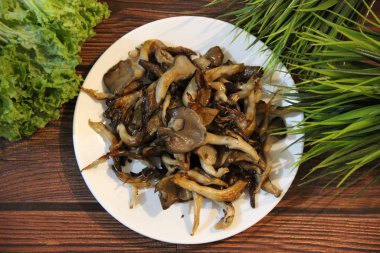 Beyaz tabakta kızarmış istiridye mantarı.