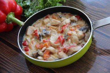 Sebzeli tavuk yahnisi ve beyaz şaraplı mantar. Yeşil bir tavada