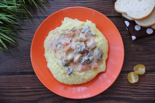 Portakal tabağında sebze ve mantarlı patates püresi ve tavuk yahnisi.