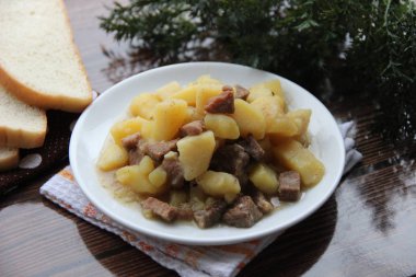 Beyaz tabakta etli haşlanmış patates.