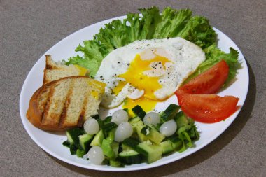 Düzgün sağlıklı yiyecekler - marul yaprağında yumurta, salatalık ve soğan salatası, ve tost makinesinde bir dilim ekmek, yan görüş