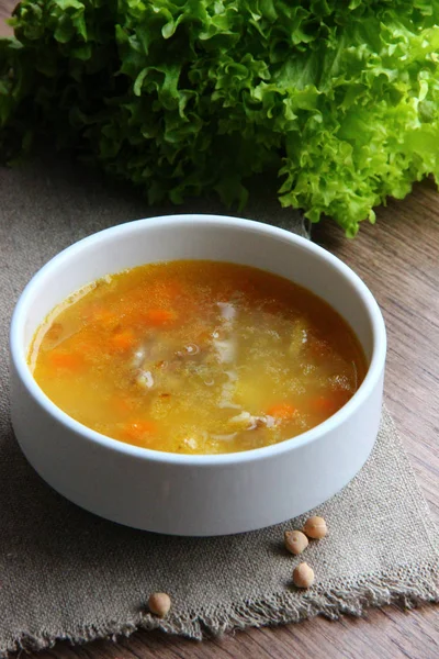 Chickpea soup in a white plate on a sackcloth, with dried chickpeas scattered nearby. Garbanzo bean soup — Stock Image Chickpea Soup White Plate Sackcloth Dried Chickpeas Scattered Nearby Garbanzo Stock Image