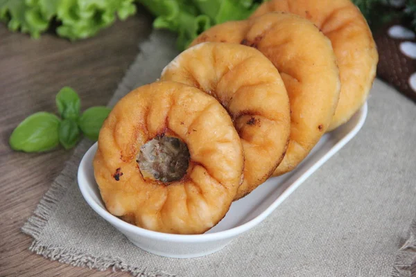 Belyashi, stacked in a row on a white plate and cloth napkin