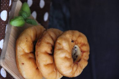 Belyashi stacked on a Board with a brown polka dot napkin and a dark background