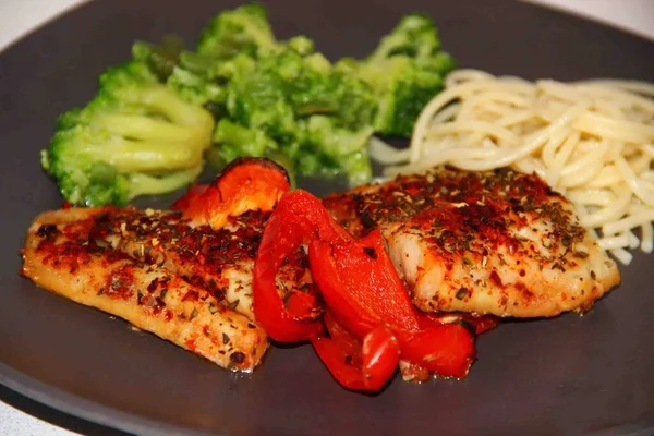 Fırında pişirilmiş tilapia otlar ve sebzelerle