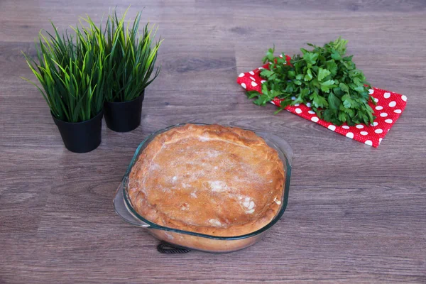 Hausgemachte Torte Mit Füllung Neben Grünzeug Auf Holzgrund — Stockfoto