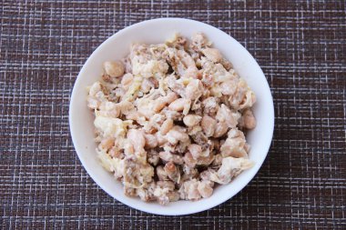 Deniz taraklı salata, konserve fasulye ve peynir yuvarlak bir fincanda.