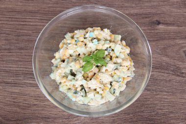 Renkli mavi yumurtalı, tavuklu, mısırlı ve şeffaf bardakta salatalıklı alışılmadık bir ev yapımı salata.