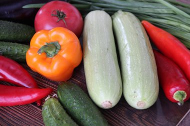 Taze domates, salatalık, patlıcan, kabak, kırmızı biber, ahşap arka planda dolmalık biber, üst manzara.